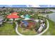 Aerial view showcasing community pool, playground, and clubhouse, all nestled within lush, green surroundings at 5816 Mezzana Run, Palmetto, FL 34221