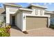 Home exterior showing front entrance, two-car garage, and lovely landscaping at 5816 Mezzana Run, Palmetto, FL 34221