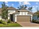 Charming home featuring a two-car garage, brick paver driveway, and manicured landscaping at 5816 Mezzana Run, Palmetto, FL 34221