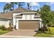 Charming home featuring a two-car garage, brick paver driveway, and manicured landscaping at 5816 Mezzana Run, Palmetto, FL 34221