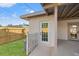 Cozy back porch area featuring a white door, partial picket fence, and well-maintained grassy yard at 5900 6Th S Way, St Petersburg, FL 33705