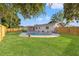 Backyard featuring a kidney-shaped pool, grass, landscaping, and fencing at 5900 6Th S Way, St Petersburg, FL 33705