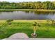 Gorgeous backyard featuring a tranquil pond view, lush lawn, and decorative tropical landscaping at 5902 106Th E Ter, Parrish, FL 34219