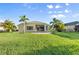 Spacious backyard featuring lush green grass, a screened-in lanai, and mature palm trees for a relaxing outdoor living at 5902 106Th E Ter, Parrish, FL 34219