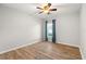 A cozy bedroom with hardwood floors, neutral walls, ceiling fan, and a window bringing in natural light at 5902 106Th E Ter, Parrish, FL 34219
