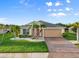 Inviting single-story home featuring lush lawn, palm trees, and a neutral color palette at 5902 106Th E Ter, Parrish, FL 34219