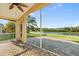 View from screened lanai with brick flooring overlooking lush, landscaped yard and lake at 5902 106Th E Ter, Parrish, FL 34219