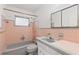 Traditional bathroom with pink tiling around a tub and a coordinated vanity at 5916 Gulfport S Blvd, Gulfport, FL 33707