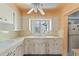 Functional kitchen with white cabinetry, ample countertop space, and a window above the sink, offering natural light at 5916 Gulfport S Blvd, Gulfport, FL 33707