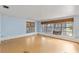 Bright living room featuring hardwood floors and natural light from multiple windows with blinds at 5916 Gulfport S Blvd, Gulfport, FL 33707
