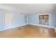 Bright living room with hardwood floors, light blue walls, and natural lighting from the window at 5916 Gulfport S Blvd, Gulfport, FL 33707