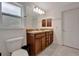 Bathroom with double sink vanity, wood cabinets, and good lighting at 6104 Plamendon Ave, North Port, FL 34291