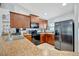 Well-lit kitchen featuring stainless steel appliances, brown cabinets, and stone countertops at 6104 Plamendon Ave, North Port, FL 34291