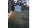 Backyard shed for storage with exterior lighting, surrounded by grass at 6104 Plamendon Ave, North Port, FL 34291