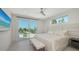 Bright bedroom features a ceiling fan and sliding glass doors to a private patio with ocean views at 6381 Gulf Of Mexico Dr, Longboat Key, FL 34228
