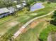 Scenic aerial view of the golf course homes overlooking the lush green, a walking path and a serene pond at 6546 Fairway Gardens Dr # 6546, Bradenton, FL 34203