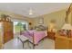 A bright bedroom offers tile floors, a ceiling fan, and a wrought iron style bedframe at 6546 Fairway Gardens Dr # 6546, Bradenton, FL 34203