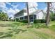 Stylish white condo featuring a screened lanai, mature landscaping, and a lush green lawn at 6546 Fairway Gardens Dr # 6546, Bradenton, FL 34203