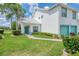 Inviting home exterior featuring a well-manicured lawn and a teal door and window trim at 6546 Fairway Gardens Dr # 6546, Bradenton, FL 34203