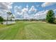 Picturesque golf course view with a calm lake, lush trees, and a residential building in the backdrop under a sunny sky at 6546 Fairway Gardens Dr # 6546, Bradenton, FL 34203
