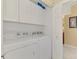 Functional laundry area with side-by-side washer and dryer, white cabinets, and storage space at 6546 Fairway Gardens Dr # 6546, Bradenton, FL 34203