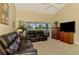 Comfortable living room featuring plush leather seating, a view of the outdoors, and natural lighting at 6546 Fairway Gardens Dr # 6546, Bradenton, FL 34203