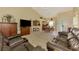 Open-concept living space features tile floors and a leather sofa set, connecting to the dining area at 6546 Fairway Gardens Dr # 6546, Bradenton, FL 34203