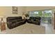 Bright living room with a plush area rug, a pair of leather sofas, and a serene view of the outdoors at 6546 Fairway Gardens Dr # 6546, Bradenton, FL 34203