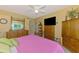 Cozy main bedroom featuring a large dresser, entertainment center, and a comfortable bed at 6546 Fairway Gardens Dr # 6546, Bradenton, FL 34203
