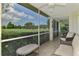 Relaxing screened patio with seating and a view of the lush green golf course and blue skies at 6546 Fairway Gardens Dr # 6546, Bradenton, FL 34203