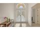 Bright foyer with tiled floors, double glass doors, and ample sunlight streaming through an arched window at 6721 Oak Manor Dr, Lakewood Ranch, FL 34202