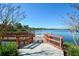Scenic lake view featuring a wooden fishing pier with a handrail on a sunny day with a clear blue sky at 6721 Oak Manor Dr, Lakewood Ranch, FL 34202