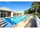 Community pool with a pool cover, pool furniture, white fencing, and palm trees on a sunny day at 6721 Oak Manor Dr, Lakewood Ranch, FL 34202