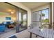 Charming lanai with seating area and view to the inside of the home and outside to the lake and golf course at 7005 River Hammock Dr # 203, Bradenton, FL 34212