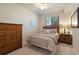 Bedroom with a wooden dresser, bedside table, and a window view at 7005 River Hammock Dr # 203, Bradenton, FL 34212