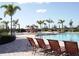 Serene community pool featuring sun loungers and palm trees, perfect for relaxation and leisure at 7005 River Hammock Dr # 203, Bradenton, FL 34212