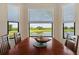 Bright dining area with scenic views, wood table, and a decorative centerpiece at 7005 River Hammock Dr # 203, Bradenton, FL 34212