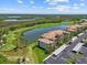 Stunning view of the condo's exterior with lake and golf course on display amidst well-manicured landscaping at 7005 River Hammock Dr # 203, Bradenton, FL 34212