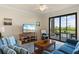 Comfortable living room with sliding door access to a screened-in lanai with views of the lake at 7005 River Hammock Dr # 203, Bradenton, FL 34212
