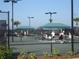 Active tennis courts with players, shade structures, and well-maintained fencing in a sunny setting at 7005 River Hammock Dr # 203, Bradenton, FL 34212