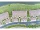 Stunning aerial view of townhomes with tile roofs, palm trees, and lush landscaping bordering a scenic lake at 7235 River Hammock Dr # 204, Bradenton, FL 34212
