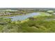 Aerial view of community homes bordering a lake, golf course, and lush green vegetation at 7235 River Hammock Dr # 204, Bradenton, FL 34212
