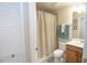 Cozy bathroom featuring a shower with curtain, toilet, and vanity with wooden cabinets at 7235 River Hammock Dr # 204, Bradenton, FL 34212