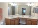 Bright bathroom with a double vanity featuring light wood cabinets, white countertops, and modern fixtures at 7235 River Hammock Dr # 204, Bradenton, FL 34212