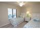 Cozy bedroom featuring two twin beds, coastal decor, and a window with a view to a balcony at 7235 River Hammock Dr # 204, Bradenton, FL 34212