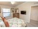 Bright bedroom features neutral colors, a queen bed, and a mounted television at 7235 River Hammock Dr # 204, Bradenton, FL 34212