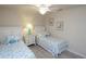 Cozy bedroom with two twin beds, coastal decor, and ceiling fan with neutral-toned walls and wood-look flooring at 7235 River Hammock Dr # 204, Bradenton, FL 34212