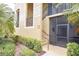 Exterior facade with stucco walls, stairs, and door with security screen at 7235 River Hammock Dr # 204, Bradenton, FL 34212