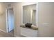 Hallway with wood-look flooring, a decorative mirror, and doors leading to other areas at 7235 River Hammock Dr # 204, Bradenton, FL 34212