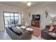Comfortable living room with leather sofas, a TV, and a view of the lake at 7235 River Hammock Dr # 204, Bradenton, FL 34212